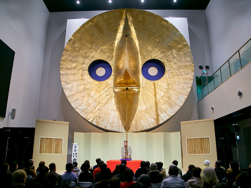 万博のシンボル「黄金の顔」を背に月亭八方、桂春之輔ら人気落語家が上方落語を披露
